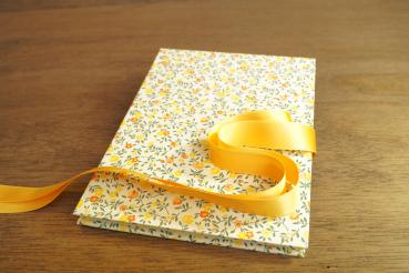 Leporello with scattered yellow flowers and a yellow bow